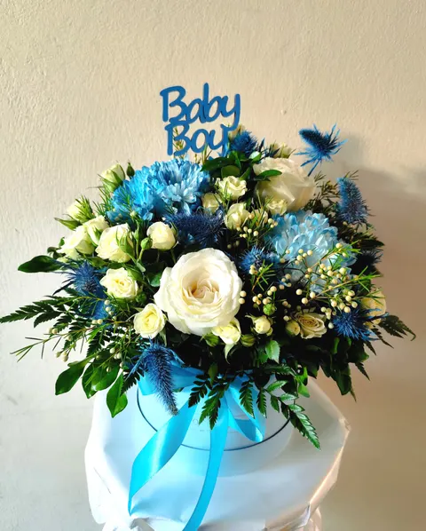 Blue rose box with roses, mini roses, chrysanthemums, wax flowers, eryngium, and greenery, elegant floral arrangement.