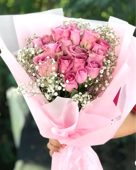 Fresh pink rose bouquet with gypsophila and elegant wrapping.